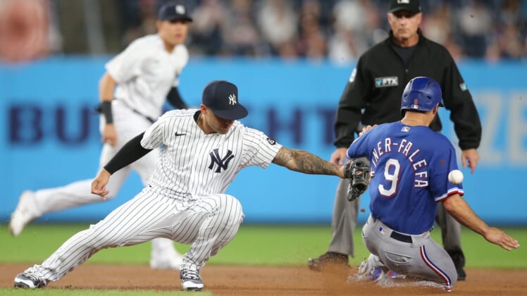 Sep 22, 2021; Bronx, New York, USA; Texas Rangers shortstop Isiah Kiner-Falefa (9) steals second base safely as the throw goes past New York Yankees second baseman Gleyber Torres (25) during the first inning at Yankee Stadium. Mandatory Credit: Brad Penner-USA TODAY Sports