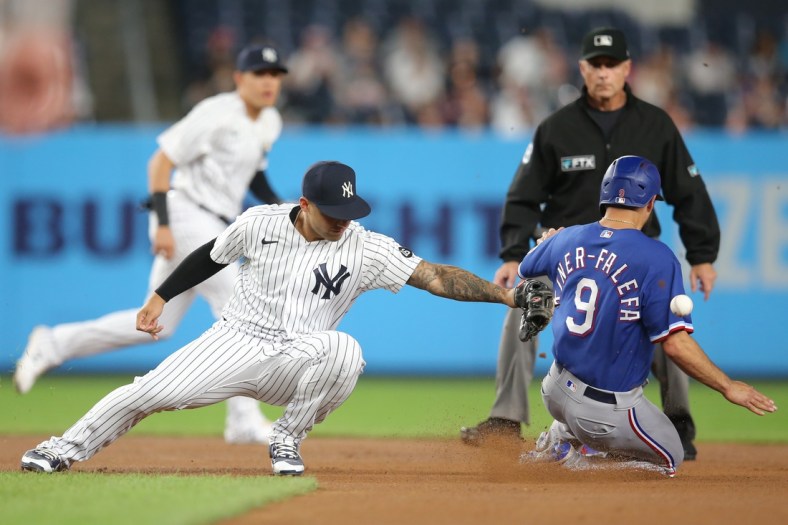 Sep 22, 2021; Bronx, New York, USA; Texas Rangers shortstop Isiah Kiner-Falefa (9) steals second base safely as the throw goes past New York Yankees second baseman Gleyber Torres (25) during the first inning at Yankee Stadium. Mandatory Credit: Brad Penner-USA TODAY Sports