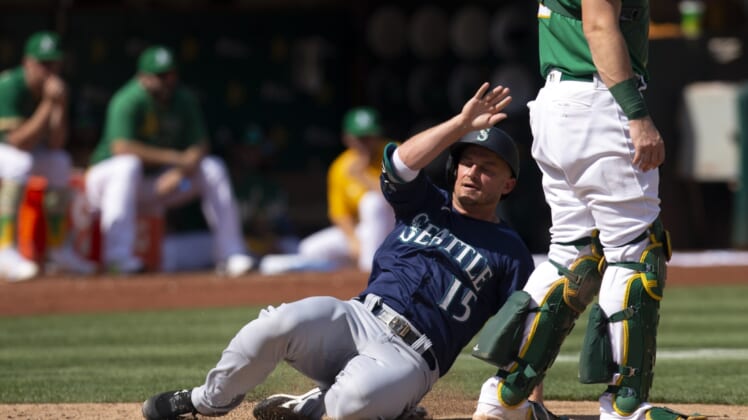 Sep 23, 2021; Oakland, California, USA; Seattle Mariners designated hitter Kyle Seager (15) slides safely home on an RBI double by Abraham Toro during the fourth inning against the Oakland Athletics at RingCentral Coliseum. Mandatory Credit: D. Ross Cameron-USA TODAY Sports