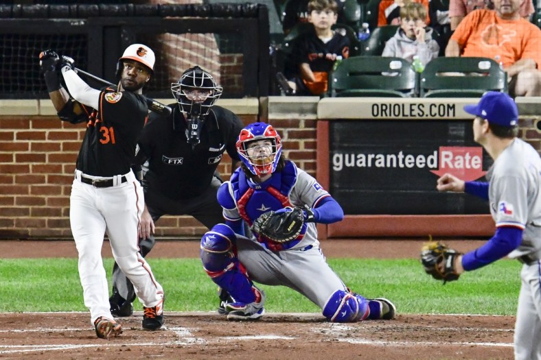 Sep 24, 2021; Baltimore, Maryland, USA;  Baltimore Orioles center fielder Cedric Mullins (31) swings through a three run home run off Texas Rangers starting pitcher Spencer Howard (31) during second inning at Oriole Park at Camden Yards. Mandatory Credit: Tommy Gilligan-USA TODAY Sports