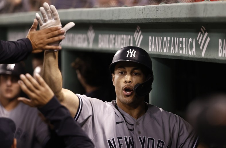 Sep 24, 2021; Boston, Massachusetts, USA; New York Yankees designated hitter Giancarlo Stanton (27) is greeted in the dugout after his three run home run against the Boston Red Sox during the third inning at Fenway Park. Mandatory Credit: Winslow Townson-USA TODAY Sports