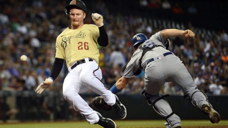 Sep 24, 2021; Phoenix, Arizona, USA; Arizona Diamondbacks first baseman Pavin Smith (26) scores a run as a throw gets away from Los Angeles Dodgers catcher Will Smith (16) during the fifth inning at Chase Field. Mandatory Credit: Joe Camporeale-USA TODAY Sports