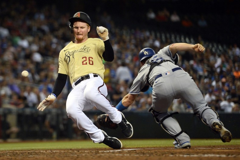 Sep 24, 2021; Phoenix, Arizona, USA; Arizona Diamondbacks first baseman Pavin Smith (26) scores a run as a throw gets away from Los Angeles Dodgers catcher Will Smith (16) during the fifth inning at Chase Field. Mandatory Credit: Joe Camporeale-USA TODAY Sports