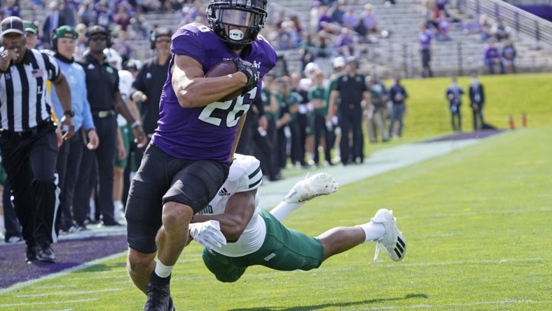 Sep 25, 2021; Evanston, Illinois, USA; Northwestern Wildcats running back Evan Hull (26) runs the ball for a touchdown as Ohio Bobcats cornerback John Gregory (13) pursues him during the first half  at Ryan Field. Mandatory Credit: David Banks-USA TODAY Sports