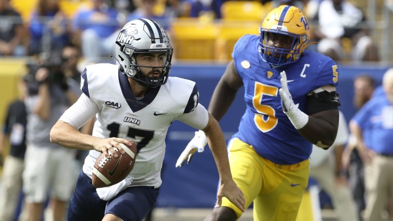 Sep 25, 2021; Pittsburgh, Pennsylvania, USA;  New Hampshire Wildcats quarterback Bret Edwards (17) scrambles with the ball as Pittsburgh Panthers defensive lineman Deslin Alexandre (5) chases during the second quarter at Heinz Field. Mandatory Credit: Charles LeClaire-USA TODAY Sports