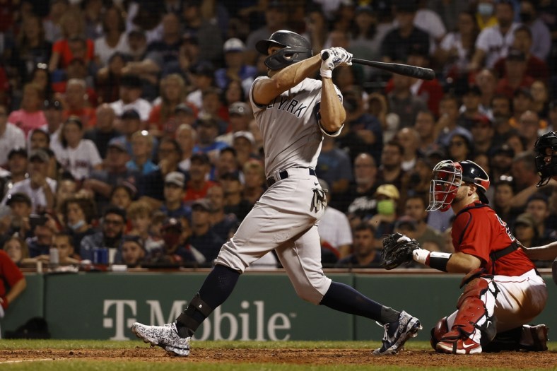 Sep 25, 2021; Boston, Massachusetts, USA; New York Yankees designated hitter Giancarlo Stanton (27) hits a grand slam home run against the Boston Red Sox during the eighth inning at Fenway Park. Mandatory Credit: Winslow Townson-USA TODAY Sports