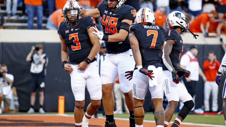 Sep 25, 2021; Stillwater, Oklahoma, USA; Oklahoma State's Spencer Sanders (3) celebrates with teammates after scoring a touchdown against the Kansas State Wildcats in the first quarter at Boone Pickens Stadium. Mandatory Credit: Sarah Phipps-USA TODAY Sports