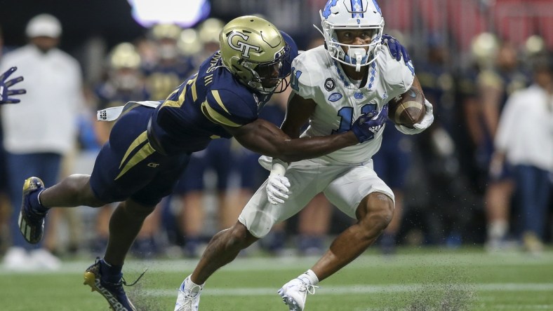 Sep 25, 2021; Atlanta, Georgia, USA; North Carolina Tar Heels wide receiver Josh Downs (11) is tackled by Georgia Tech Yellow Jackets linebacker Charlie Thomas (25) in the first quarter at Mercedes-Benz Stadium. Mandatory Credit: Brett Davis-USA TODAY Sports