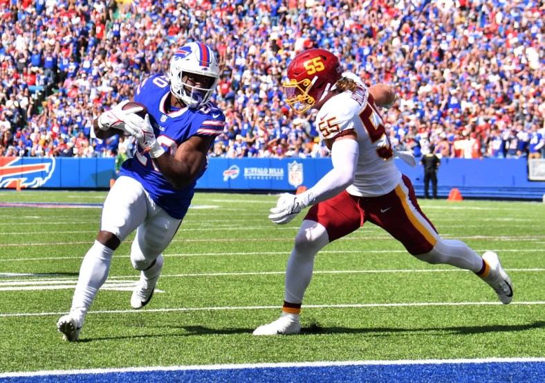 Sep 26, 2021; Orchard Park, New York, USA; Buffalo Bills running back Zack Moss (20) scores a touchdown beating Washington Football Team linebacker Cole Holcomb (55) to the end zone in the second quarter at Highmark Stadium. Mandatory Credit: Mark Konezny-USA TODAY Sports
