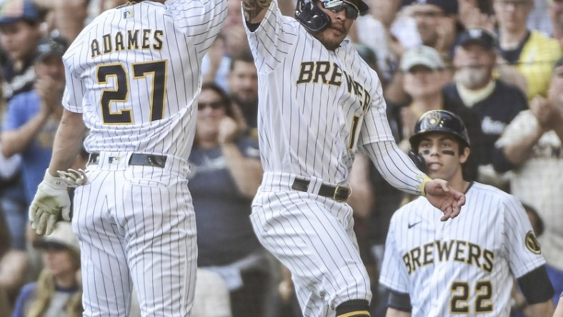 Sep 26, 2021; Milwaukee, Wisconsin, USA;  Milwaukee Brewers shortstop Willy Adames (27) celebrates with second baseman Kolten Wong (16) after hitting a two-run homer in the first inning against the New York Mets at American Family Field. Mandatory Credit: Benny Sieu-USA TODAY Sports