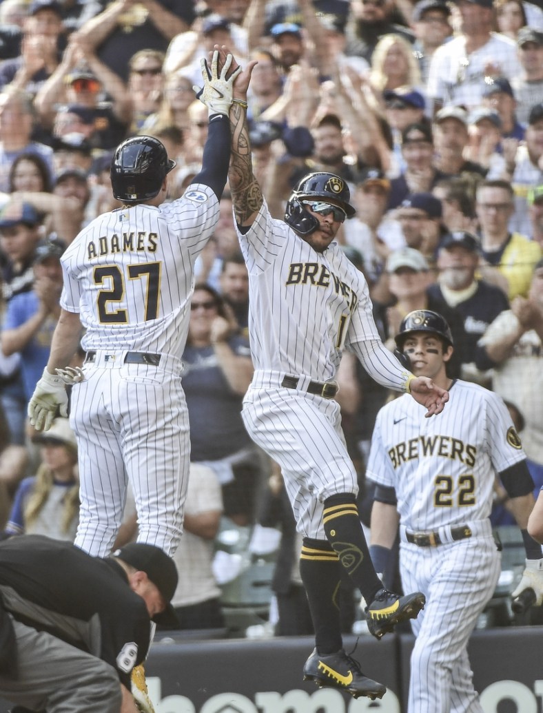 Sep 26, 2021; Milwaukee, Wisconsin, USA;  Milwaukee Brewers shortstop Willy Adames (27) celebrates with second baseman Kolten Wong (16) after hitting a two-run homer in the first inning against the New York Mets at American Family Field. Mandatory Credit: Benny Sieu-USA TODAY Sports