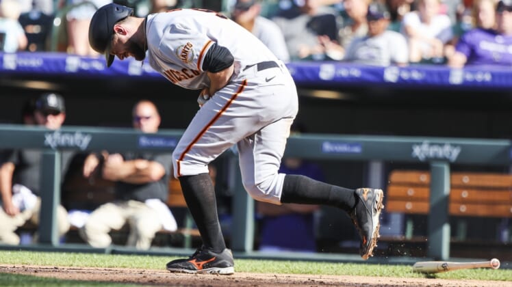 Sep 26, 2021; Denver, Colorado, USA; San Francisco Giants first baseman Brandon Belt (9) reacts after being hit by a pitch while attempting to bunt against the Colorado Rockies in the seventh inning at Coors Field. Mandatory Credit: Michael Ciaglo-USA TODAY Sports
