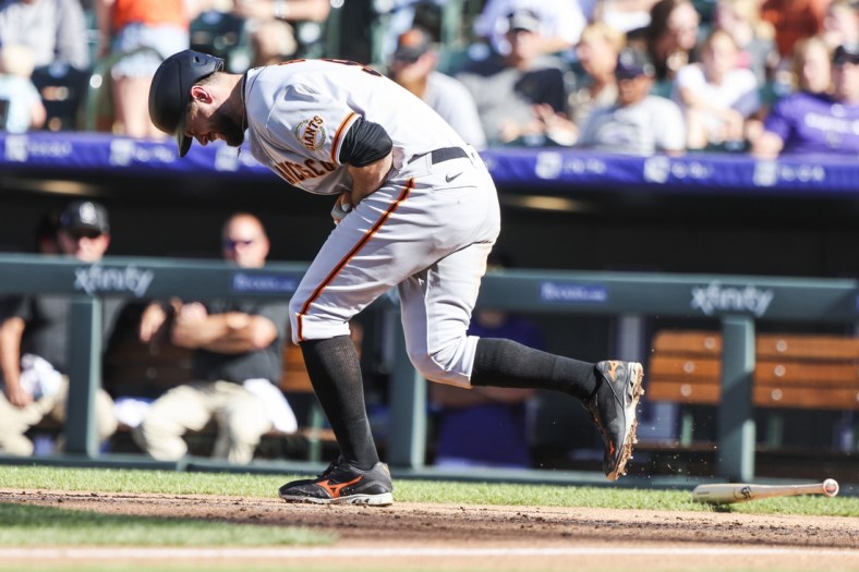 Sep 26, 2021; Denver, Colorado, USA; San Francisco Giants first baseman Brandon Belt (9) reacts after being hit by a pitch while attempting to bunt against the Colorado Rockies in the seventh inning at Coors Field. Mandatory Credit: Michael Ciaglo-USA TODAY Sports