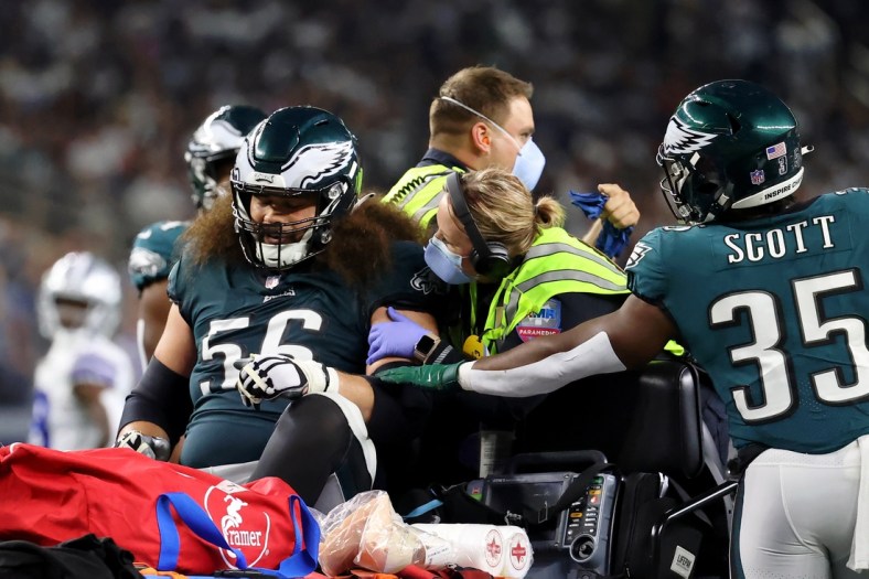 Sep 27, 2021; Arlington, Texas, USA; Philadelphia Eagles offensive guard Isaac Seumalo (56) is consoled by running back Boston Scott (35) as he is taken off the field on a cart after sustaining an apparent injury during the fourth quarter of their game against the Dallas Cowboys at AT&T Stadium. Mandatory Credit: Kevin Jairaj-USA TODAY Sports