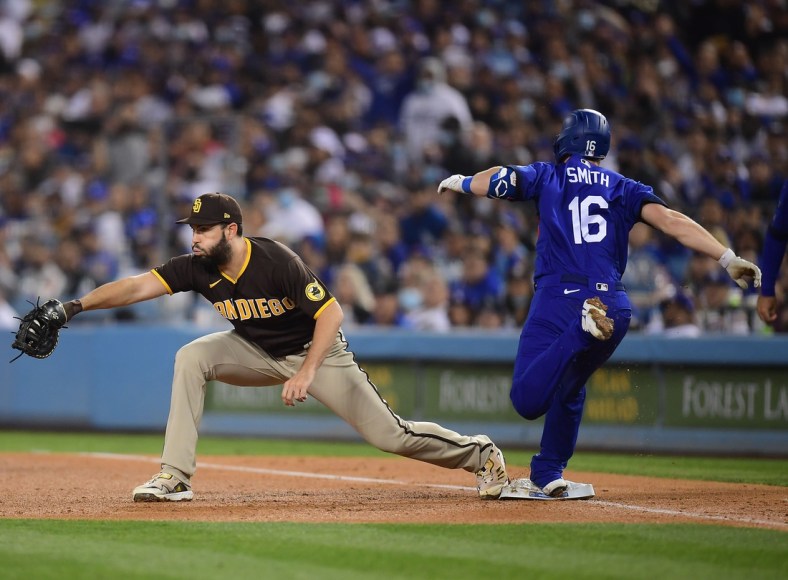 Sep 28, 2021; Los Angeles, California, USA; Los Angeles Dodgers catcher Will Smith (16) is out at first against San Diego Padres first baseman Eric Hosmer (30) during the third inning at Dodger Stadium. Mandatory Credit: Gary A. Vasquez-USA TODAY Sports