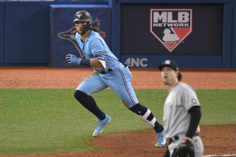 Sep 29, 2021; Toronto, Ontario, CAN; Toronto Blue Jays shortstop Bo Bichette (left) rounds the bases after hitting a solo home run against New York Yankees pitcher Gerrit Cole (front) in the third inning at Rogers Centre. Mandatory Credit: Dan Hamilton-USA TODAY Sports