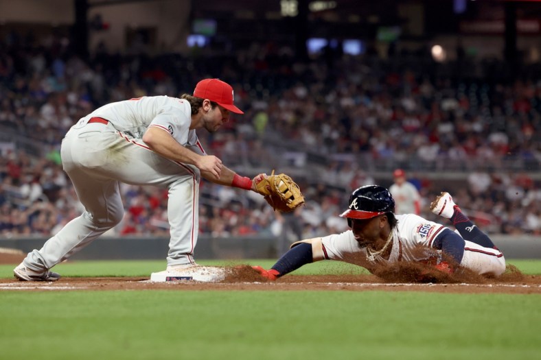Sep 29, 2021; Atlanta, Georgia, USA; Atlanta Braves second baseman Ozzie Albies (1) slides back to first base safely on a pickoff attempt by Philadelphia Phillies first baseman Matt Vierling (19) during the third inning at Truist Park. Mandatory Credit: Jason Getz-USA TODAY Sports