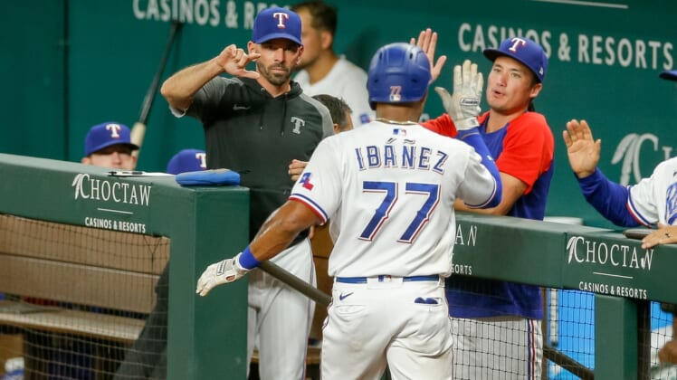 Sep 29, 2021; Arlington, Texas, USA; Texas Rangers second baseman Andy Ibanez (77) celebrates with manager Chris Woodward (8) after scoring against the Los Angeles Angels during the fourth inning at Globe Life Field. Mandatory Credit: Andrew Dieb-USA TODAY Sports