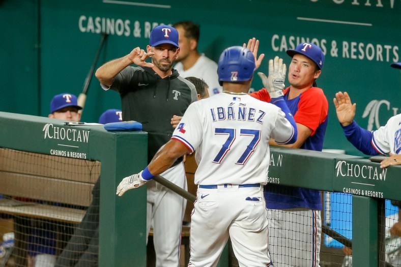 Sep 29, 2021; Arlington, Texas, USA; Texas Rangers second baseman Andy Ibanez (77) celebrates with manager Chris Woodward (8) after scoring against the Los Angeles Angels during the fourth inning at Globe Life Field. Mandatory Credit: Andrew Dieb-USA TODAY Sports