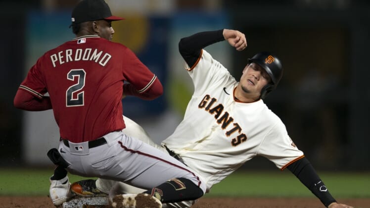 Sep 29, 2021; San Francisco, California, USA; Arizona Diamondbacks shortstop Geraldo Perdomo (2) takes the relay in time to force out San Francisco Giants first baseman Wilmer Flores (right) at second base during the second inning at Oracle Park. Mandatory Credit: D. Ross Cameron-USA TODAY Sports