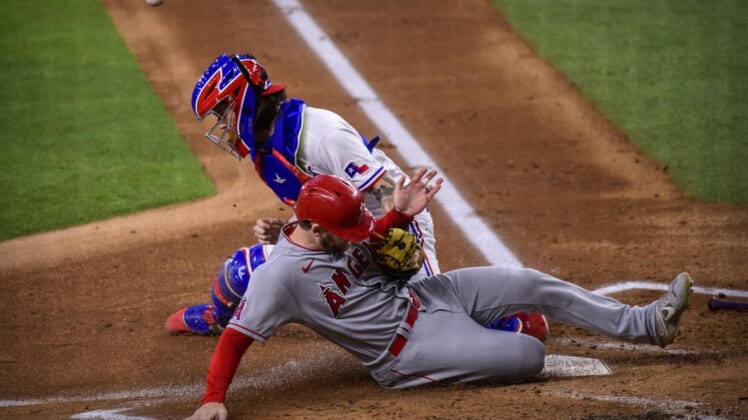 Sep 30, 2021; Arlington, Texas, USA; Los Angeles Angels left fielder Taylor Ward (3) slides safely into home plate as Texas Rangers catcher Jonah Heim (28) cannot make the tag during the first inning at Globe Life Field. Mandatory Credit: Jerome Miron-USA TODAY Sports