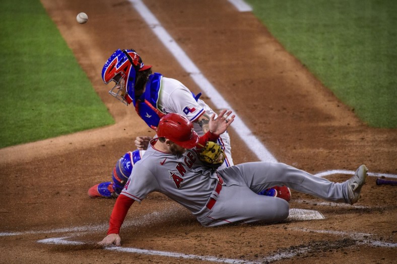 Sep 30, 2021; Arlington, Texas, USA; Los Angeles Angels left fielder Taylor Ward (3) slides safely into home plate as Texas Rangers catcher Jonah Heim (28) cannot make the tag during the first inning at Globe Life Field. Mandatory Credit: Jerome Miron-USA TODAY Sports