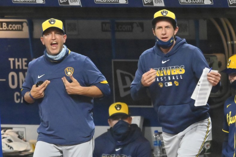Sep 4, 2020; Cleveland, Ohio, USA; Milwaukee Brewers hitting coach Andy Haines (49), left and manager Craig Counsell (30) react to a strike call in the seventh inning against the Cleveland Indians at Progressive Field. Haines was ejected from the game. Mandatory Credit: David Richard-USA TODAY Sports