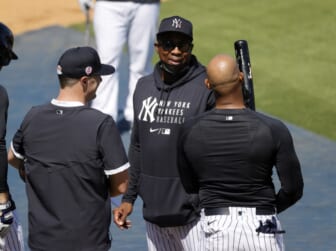 Oct 9, 2020; San Diego, California, USA; New York Yankees designated hitter Giancarlo Stanton (27) fist bumps first base coach Reggie Willits (50) after drawing a walk against the Tampa Bay Rays during the sixth inning of game five of the 2020 ALDS at Petco Park. Mandatory Credit: Orlando Ramirez-USA TODAY Sports