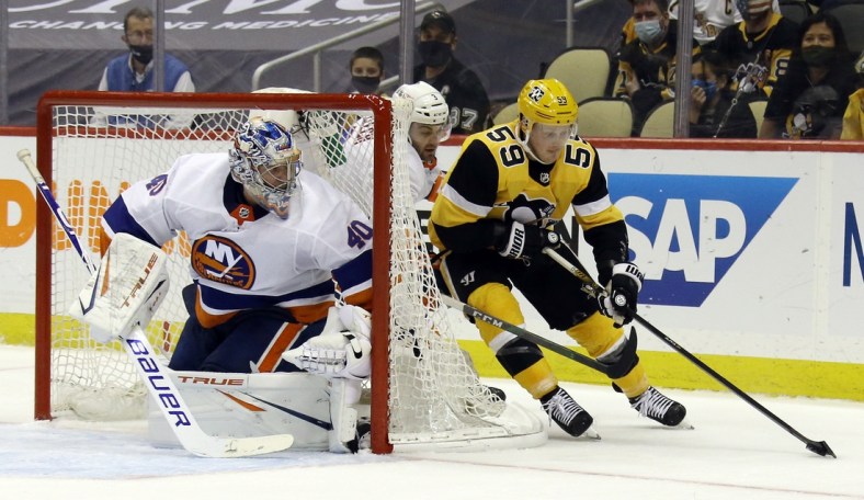 May 18, 2021; Pittsburgh, Pennsylvania, USA;  /New York Islanders goaltender Semyon Varlamov (40) and defenseman Adam Pelech (3) defend a wrap around attempt by Pittsburgh Penguins left wing Jake Guentzel (59) during the third period in game two of the first round of the 2021 Stanley Cup Playoffs at PPG Paints Arena. Pittsburgh won 2-1.  Mandatory Credit: Charles LeClaire-USA TODAY Sports