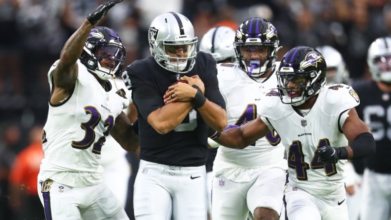 Sep 13, 2021; Paradise, Nevada, USA; Las Vegas Raiders quarterback Marcus Mariota (8) is tackled by Baltimore Ravens defensive back DeShon Elliott (32) and cornerback Marlon Humphrey (44) during the first half at Allegiant Stadium. Mandatory Credit: Mark J. Rebilas-USA TODAY Sports