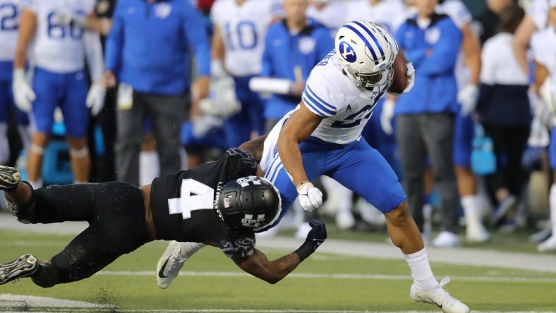 Oct 1, 2021; Logan, Utah, USA; Utah State Aggies running back Calvin Tyler Jr. (4) attempts to tackle Brigham Young Cougars defensive back Talan Alfrey (25) as he runs for a touchdown during the first quarter at Merlin Olsen Field at Maverik Stadium. Mandatory Credit: Rob Gray-USA TODAY Sports