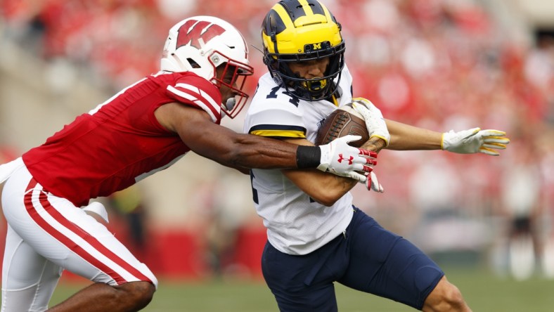 Oct 2, 2021; Madison, Wisconsin, USA;  Michigan Wolverines wide receiver Roman Wilson (14) is tackled after catching a pass during the first quarter against the Wisconsin Badgers at Camp Randall Stadium. Mandatory Credit: Jeff Hanisch-USA TODAY Sports