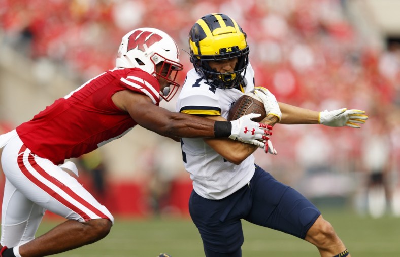 Oct 2, 2021; Madison, Wisconsin, USA;  Michigan Wolverines wide receiver Roman Wilson (14) is tackled after catching a pass during the first quarter against the Wisconsin Badgers at Camp Randall Stadium. Mandatory Credit: Jeff Hanisch-USA TODAY Sports