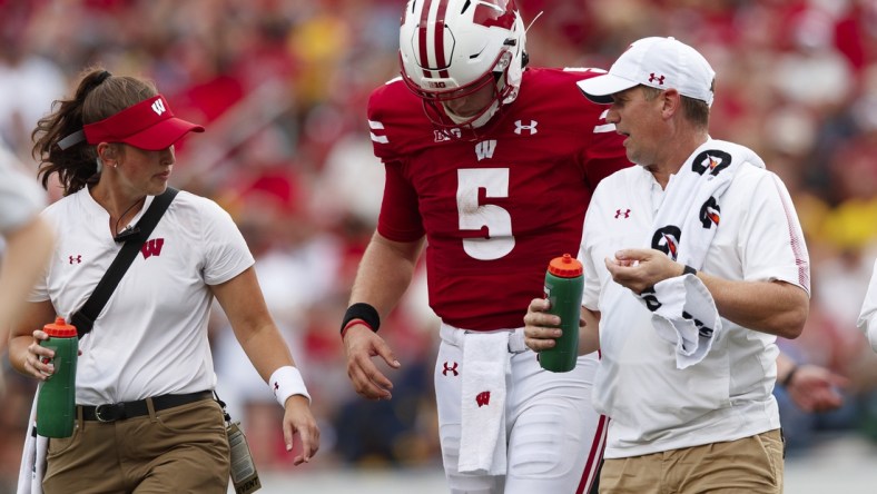 Oct 2, 2021; Madison, Wisconsin, USA;  Wisconsin Badgers quarterback Graham Mertz (5) walks from the field after being injured during the third quarter against the Michigan Wolverines at Camp Randall Stadium. Mandatory Credit: Jeff Hanisch-USA TODAY Sports