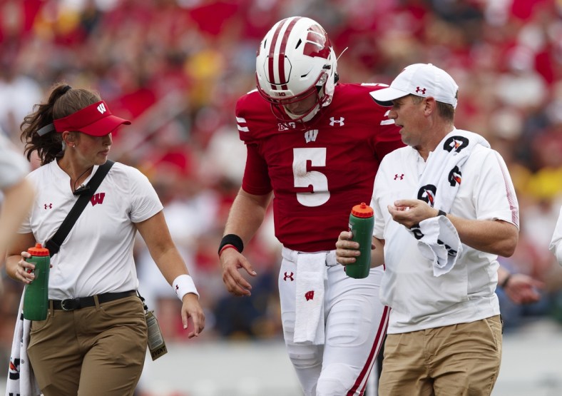 Oct 2, 2021; Madison, Wisconsin, USA;  Wisconsin Badgers quarterback Graham Mertz (5) walks from the field after being injured during the third quarter against the Michigan Wolverines at Camp Randall Stadium. Mandatory Credit: Jeff Hanisch-USA TODAY Sports