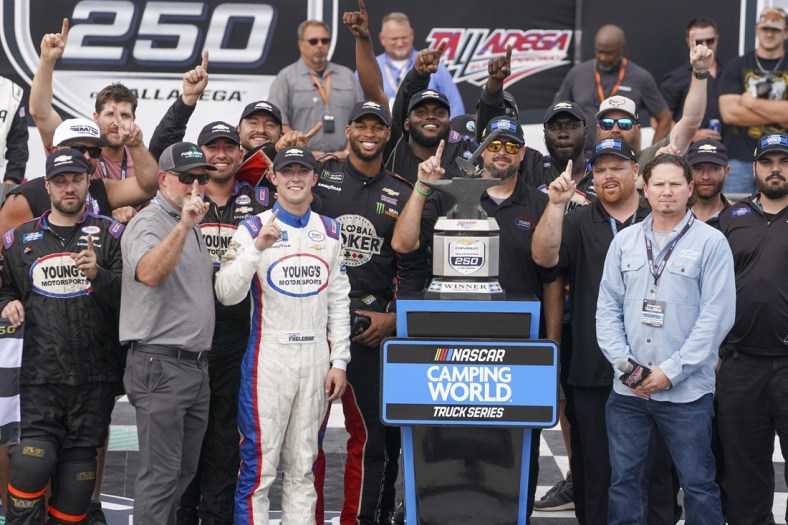 Oct 2, 2021; Talladega Speedway, AL, USA; NASCAR Gander RV and Outdoors Truck Series driver Tate Fogleman (12) holds up the number one as he poses with his team after winning the race at Talladega Speedway. Mandatory Credit: Marvin Gentry-USA TODAY Sports