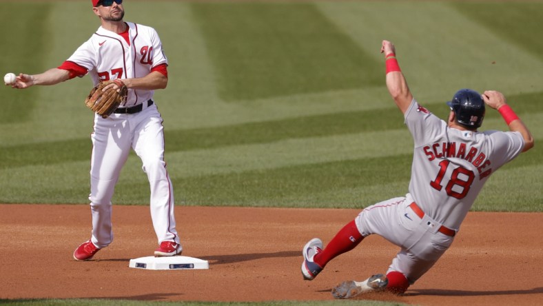 Oct 3, 2021; Washington, District of Columbia, USA; Washington Nationals shortstop Jordy Mercer (27) turns a double play ahead of the slide of Boston Red Sox left fielder Kyle Schwarber (18) during the first inning at Nationals Park. Mandatory Credit: Geoff Burke-USA TODAY Sports