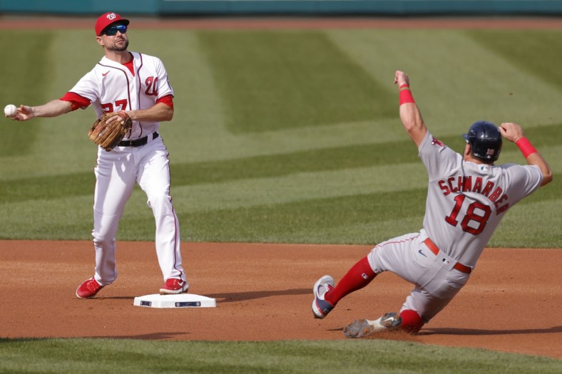 Oct 3, 2021; Washington, District of Columbia, USA; Washington Nationals shortstop Jordy Mercer (27) turns a double play ahead of the slide of Boston Red Sox left fielder Kyle Schwarber (18) during the first inning at Nationals Park. Mandatory Credit: Geoff Burke-USA TODAY Sports