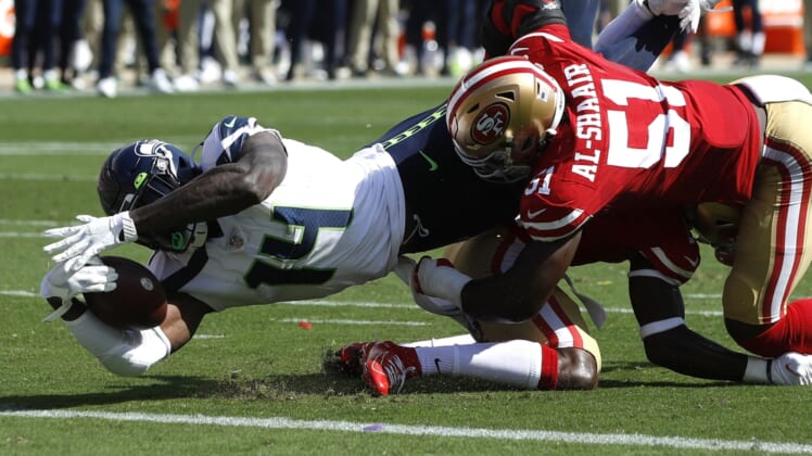 Oct 3, 2021; Santa Clara, California, USA; Seattle Seahawks wide receiver DK Metcalf (14) dives for the end zone while being tackled by San Francisco 49ers linebacker Azeez Al-Shaair (51) and cornerback Jimmie Ward (1) during the second quarter at Levi's Stadium. Mandatory Credit: Darren Yamashita-USA TODAY Sports