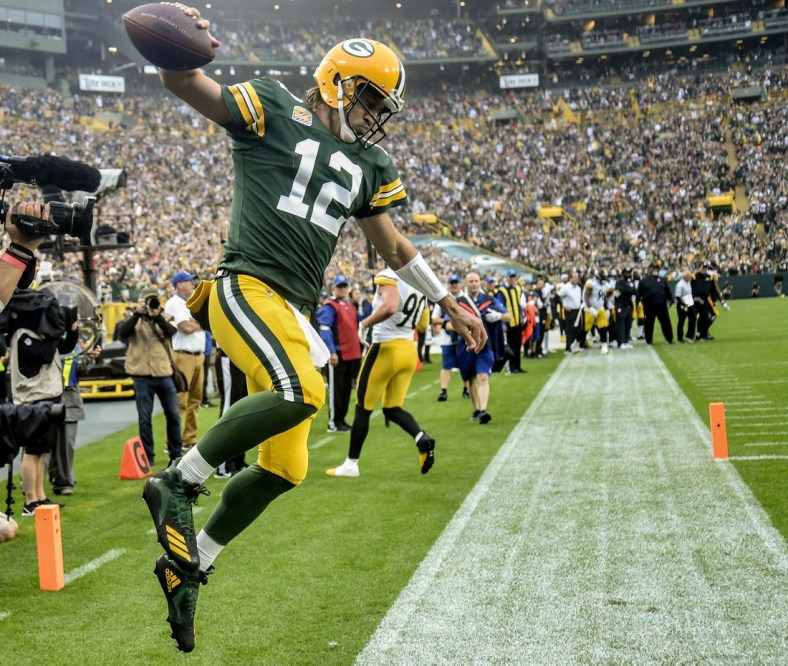 Oct 3, 2021; Green Bay, Wisconsin, USA; Green Bay Packers quarterback Aaron Rodgers (12) celebrates after scoring a touchdown in the second quarter against the Pittsburgh Steelers at Lambeau Field. Mandatory Credit: Benny Sieu-USA TODAY Sports