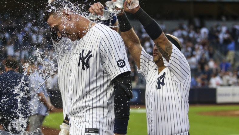 Oct 3, 2021; Bronx, New York, USA;  New York Yankees right fielder Aaron Judge (99) is doused with water after his game winning RBI single to defeat the Tampa Bay Rays 1-0 and clinch a wildcard playoff spot at Yankee Stadium. Mandatory Credit: Wendell Cruz-USA TODAY Sports