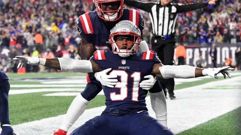 Oct 3, 2021; Foxborough, Massachusetts, USA;  New England Patriots free safety Devin McCourty (32) celebrates with defensive back Jonathan Jones (31) after breaking up a pass in the end zone during the second half of a game against the Tampa Bay Buccaneers at Gillette Stadium. Mandatory Credit: Brian Fluharty-USA TODAY Sports