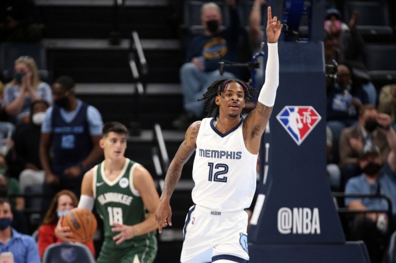 Oct 5, 2021; Memphis, Tennessee, USA; Memphis Grizzles guard Ja Morant (12) celebrates after a dunk against the Milwaukee Bucks during the third quarter at FedExForum. Mandatory Credit: Petre Thomas-USA TODAY Sports