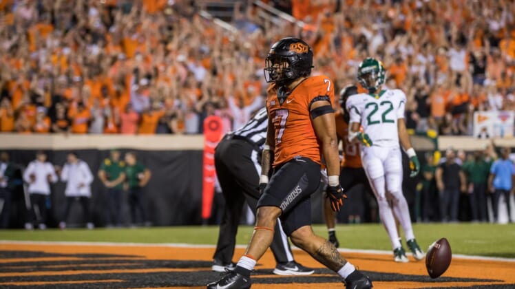 Oct 2, 2021; Stillwater, Oklahoma, USA;  Oct 2, 2021; Stillwater, Oklahoma, USA; Oklahoma State Cowboys running back Jaylen Warren (7) drops the ball after scoring a touchdown during the fourth quarter against the Baylor Bears at Boone Pickens Stadium. OSU won 24-14. Mandatory Credit: Brett Rojo-USA TODAY Sports