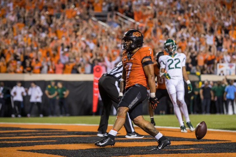 Oct 2, 2021; Stillwater, Oklahoma, USA;  Oct 2, 2021; Stillwater, Oklahoma, USA; Oklahoma State Cowboys running back Jaylen Warren (7) drops the ball after scoring a touchdown during the fourth quarter against the Baylor Bears at Boone Pickens Stadium. OSU won 24-14. Mandatory Credit: Brett Rojo-USA TODAY Sports