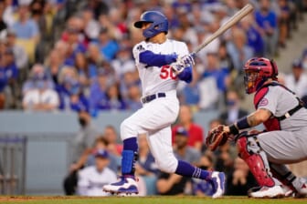 Oct 6, 2021; Los Angeles, California, USA; Los Angeles Dodgers right fielder Mookie Betts (50) hits a single against the St. Louis Cardinals the third inning at Dodger Stadium. Mandatory Credit: Robert Hanashiro-USA TODAY Sports