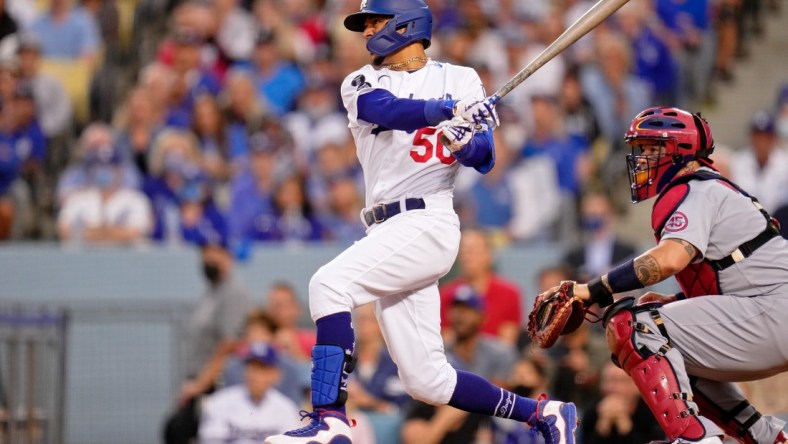 Oct 6, 2021; Los Angeles, California, USA; Los Angeles Dodgers right fielder Mookie Betts (50) hits a single against the St. Louis Cardinals the third inning at Dodger Stadium. Mandatory Credit: Robert Hanashiro-USA TODAY Sports