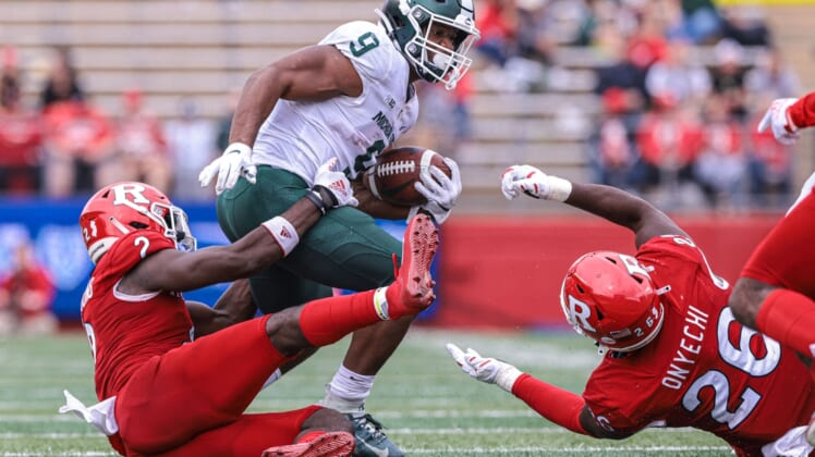 Oct 9, 2021; Piscataway, New Jersey, USA; Michigan State Spartans running back Kenneth Walker III (9) is tackled by Rutgers Scarlet Knights defensive back Avery Young (2) and defensive lineman CJ Onyechi (26) during the second half at SHI Stadium. Mandatory Credit: Vincent Carchietta-USA TODAY Sports