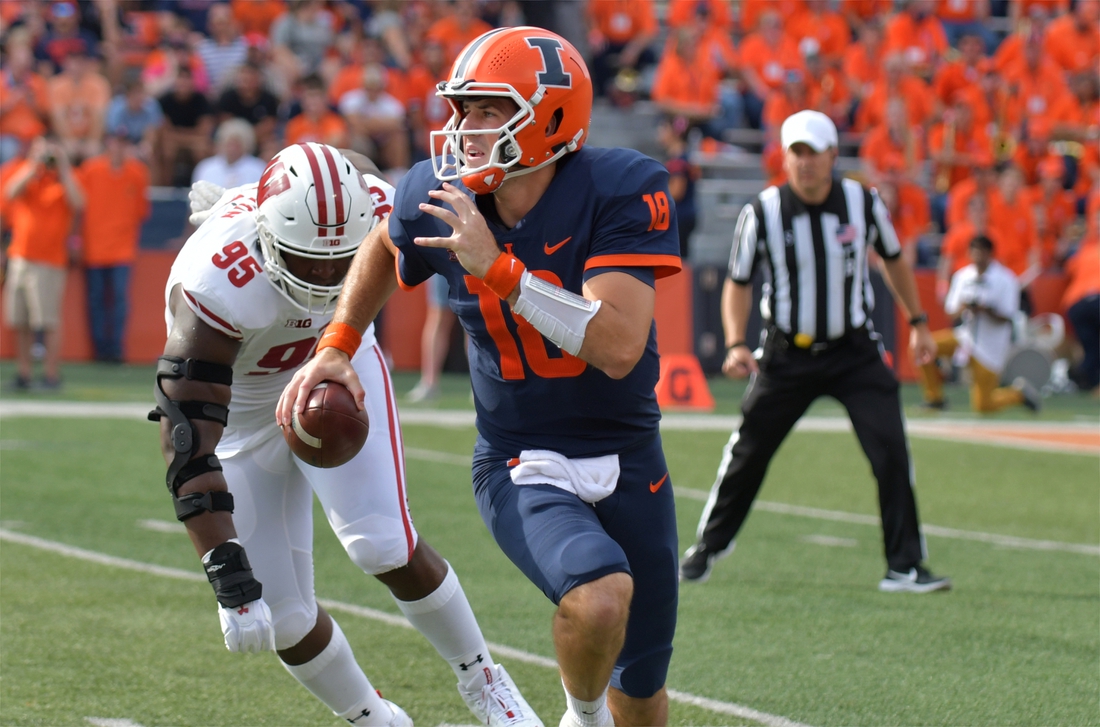 Oct 9, 2021; Champaign, Illinois, USA;  Illinois Fighting Illini quarterback Brandon Peters (18) runs with the ball as Wisconsin Badgers defensive tackle Keeanu Benton (95) pursues in the first half at Memorial Stadium. Mandatory Credit: Ron Johnson-USA TODAY Sports