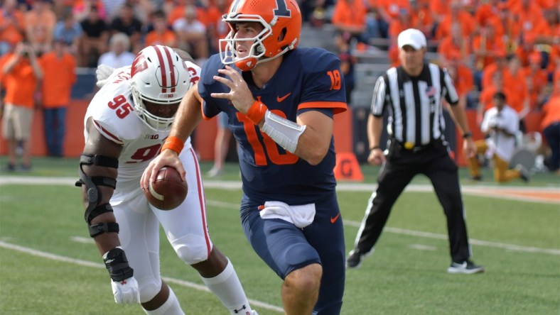 Oct 9, 2021; Champaign, Illinois, USA;  Illinois Fighting Illini quarterback Brandon Peters (18) runs with the ball as Wisconsin Badgers defensive tackle Keeanu Benton (95) pursues in the first half at Memorial Stadium. Mandatory Credit: Ron Johnson-USA TODAY Sports